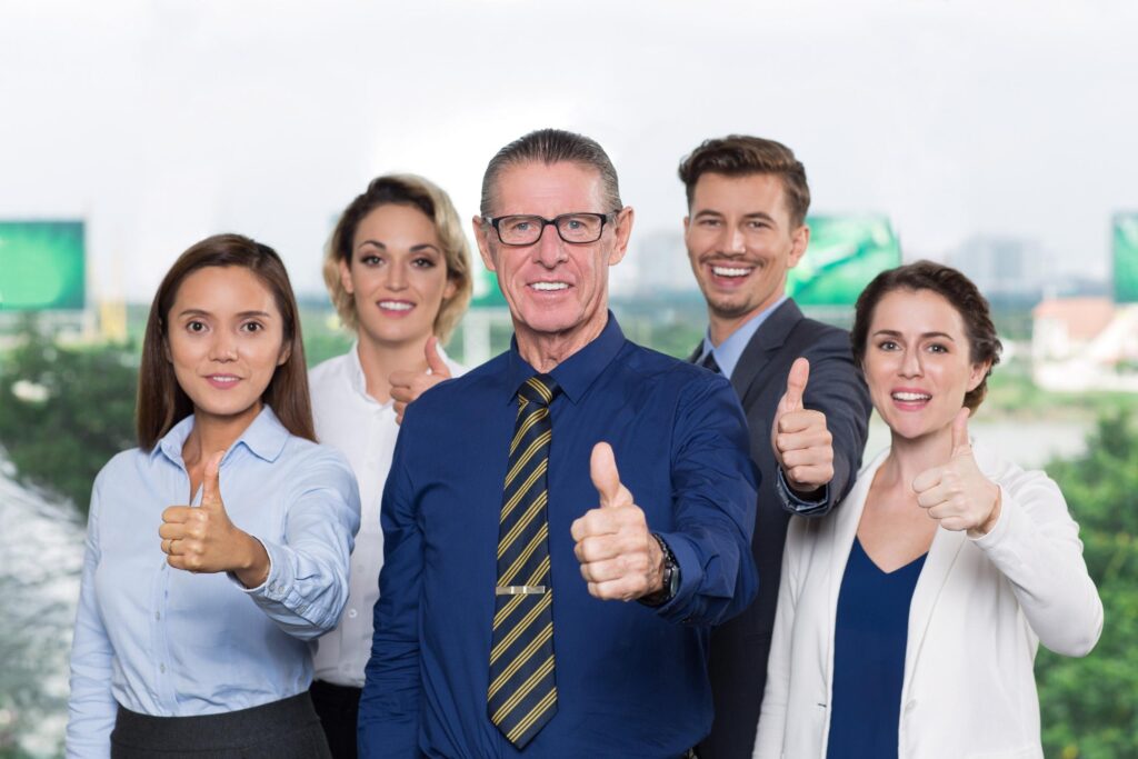 Ejecutivos sonrientes con pulgar arriba demuestran buen gobierno corporativo