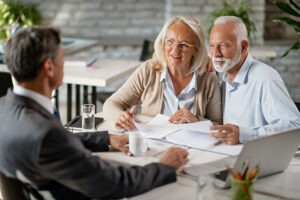 Pareja de adultos mayores conversan con abogado para hacer testamnto
